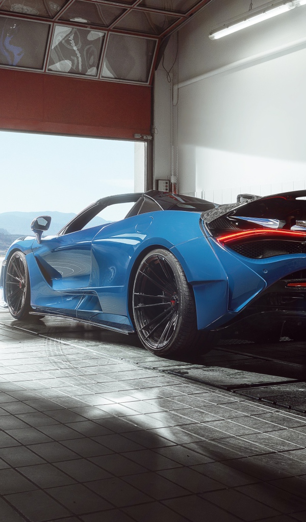 Спортивный автомобиль  McLaren 720S, 2020 года выезжает с гаража