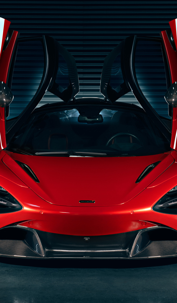 Красный автомобиль McLaren 720S с открытыми дверями в гараже