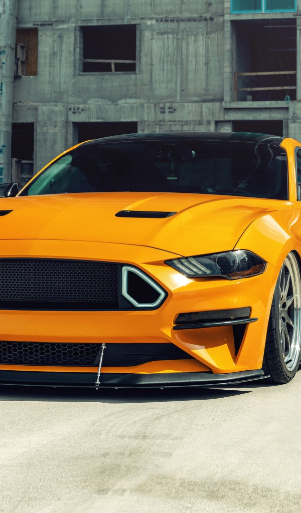 Оранжевый автомобиль  Mustang на стройке 