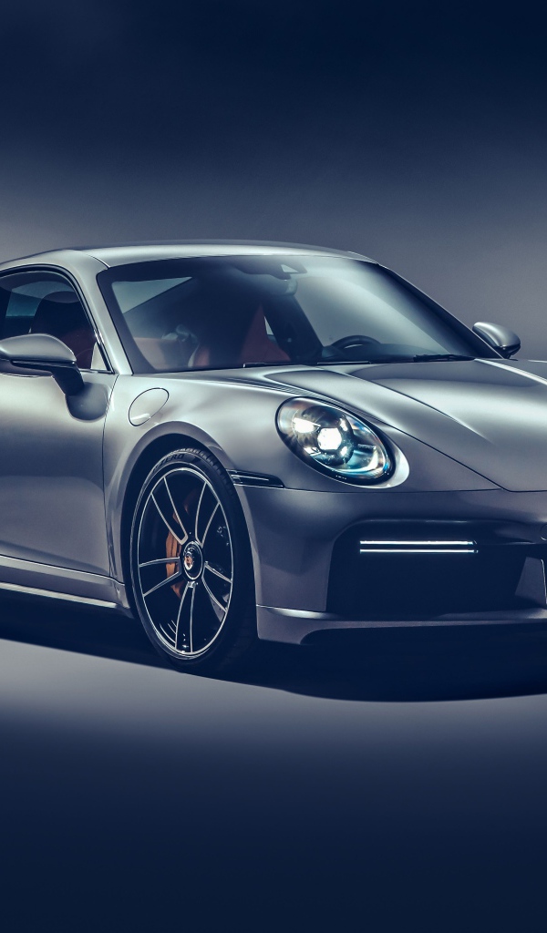 Автомобиль Porsche 911 Turbo S 2020 года на сером фоне