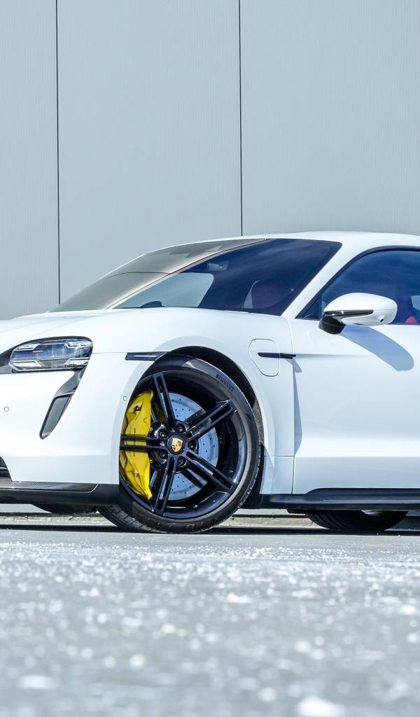 Белый автомобиль Porsche Taycan Turbo S 2020 года в лучах солнца 