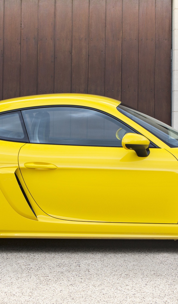Желтый автомобиль Porsche 718 Cayman GT4 2020 года вид сбоку