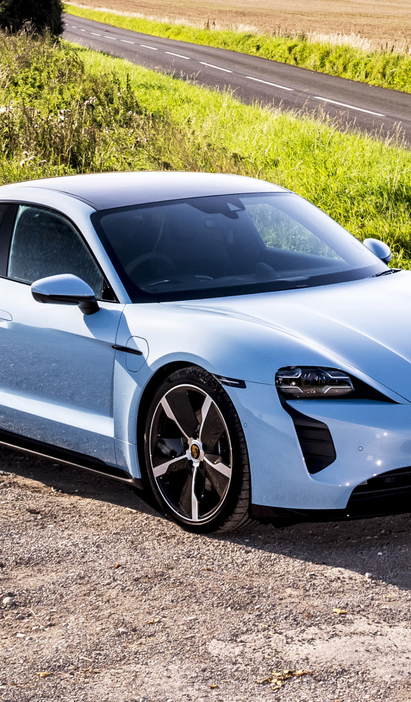 Быстрый автомобиль Porsche Taycan 4S 2021 года на фоне поля