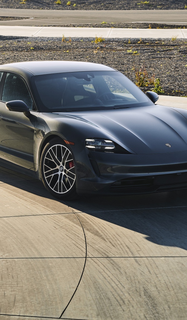 Черный автомобиль Porsche Taycan, 2020 года на дороге 