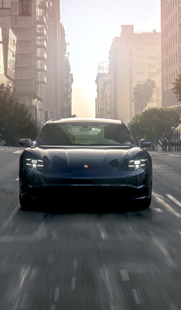 Черный стильный автомобиль  Porsche Taycan Turbo, 2020 года на дороге в городе