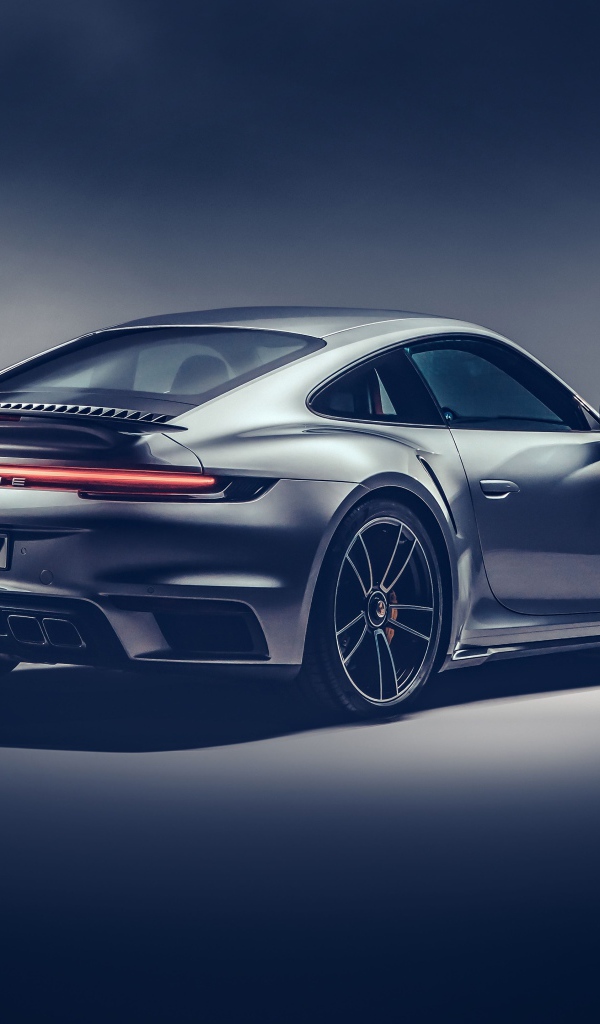 Автомобиль Porsche 911 Turbo S 2020 года на сером фоне вид сзади