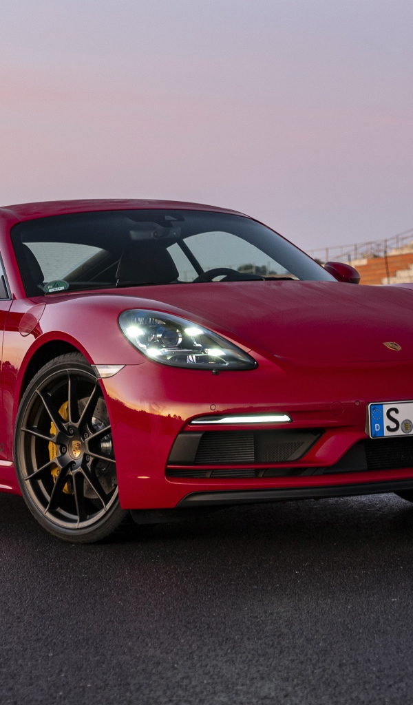 Красный автомобиль Porsche 718 Cayman GTS 4,  2020  года на стадионе