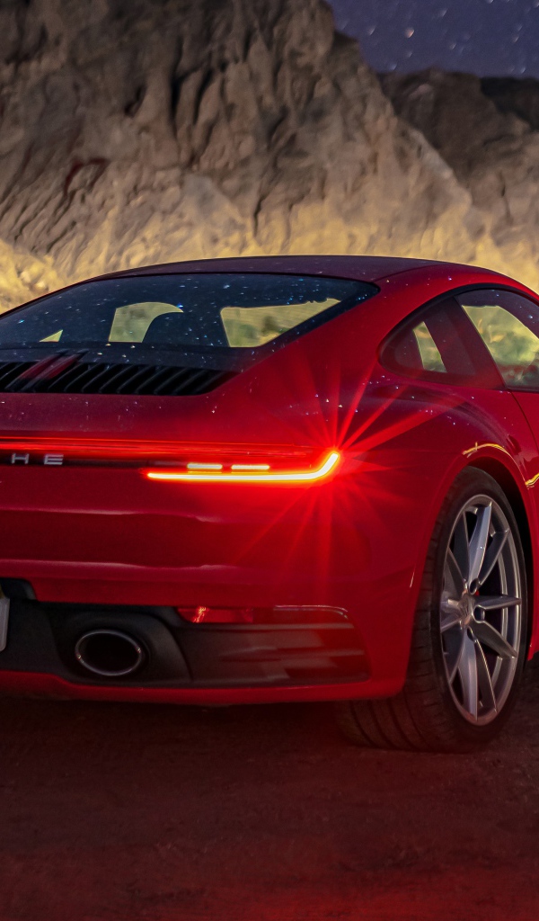 Красный автомобиль  Porsche 911 Carrera S, 2020 года в горах ночью 
