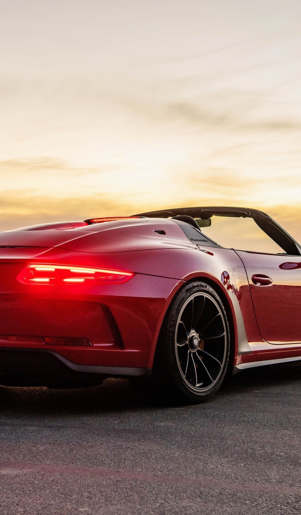 Красный автомобиль Porsche 911 Speedster, 2019 года у моря на закате