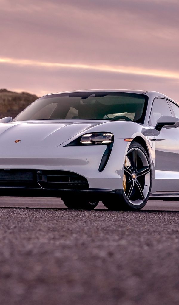 Серебристый автомобиль Porsche Taycan Turbo S 2020 года на фоне неба