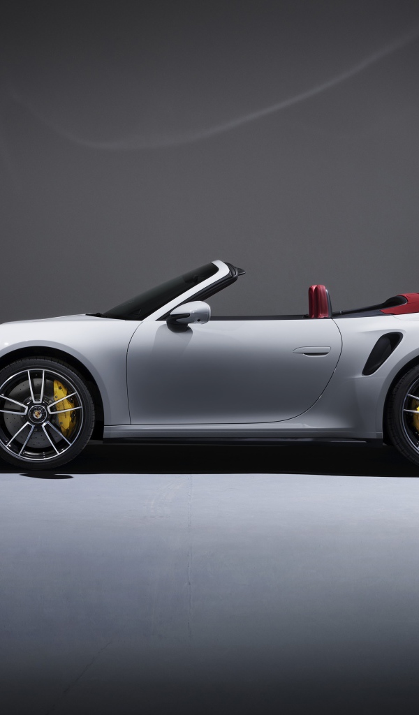 Белый автомобиль Porsche 911 Turbo S Cabriolet 2020 года на сером фоне