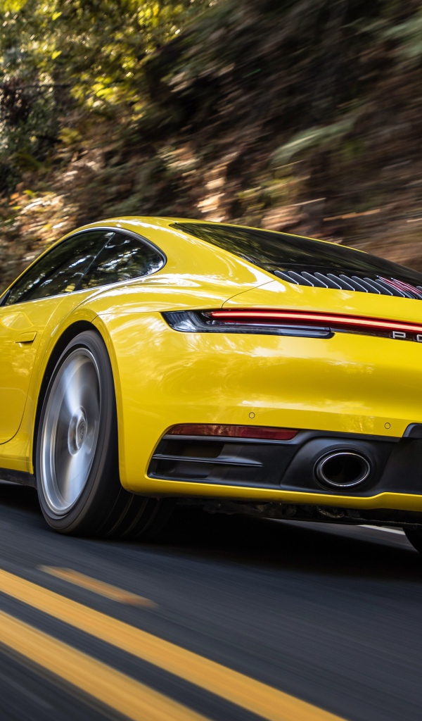Желтый автомобиль  Porsche 911 Carrera 4S, 2020 года на трассе 