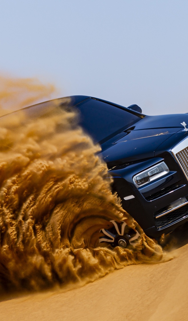 Черный Rolls-Royce Cullinan дрифтует по песку 