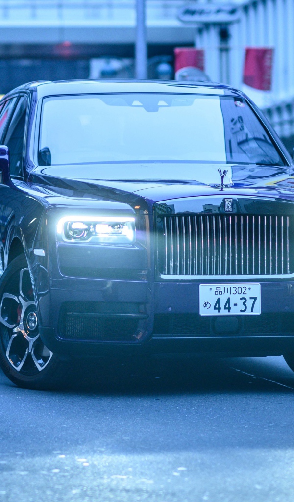 Автомобиль Rolls-Royce Cullinan с включенными фарами