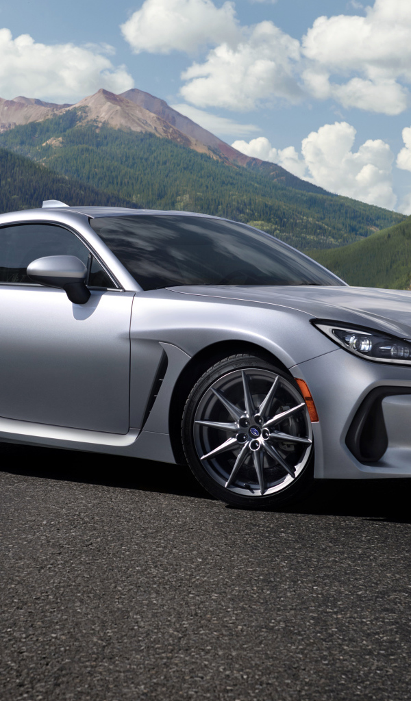 Серебристый автомобиль Subaru BRZ, 2022 года на фоне гор