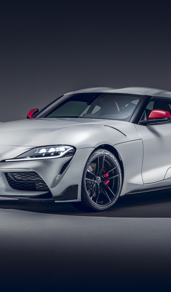 Серебристый автомобиль Toyota GR Supra 2L 2020 года на сером фоне