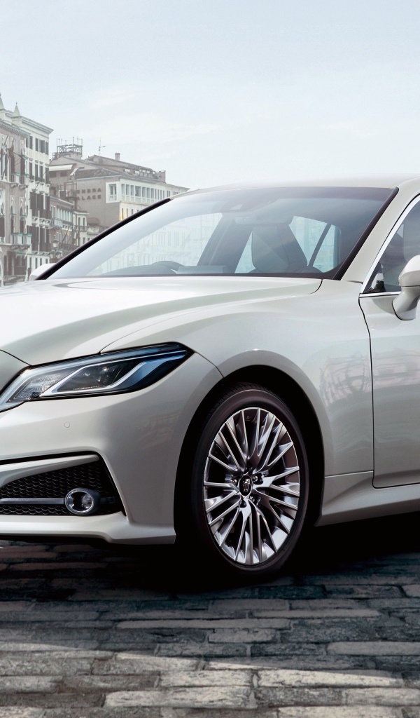 Стильный автомобиль Toyota Crown S, 2020 года на фоне здания