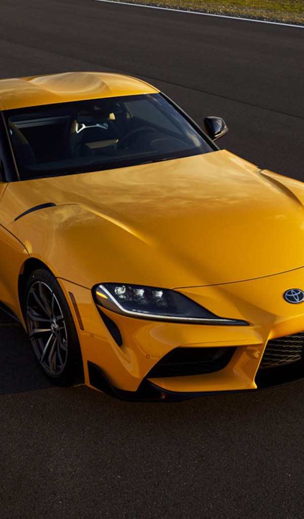 Желтый автомобиль  Toyota GR Supra, 2021 года на трассе 