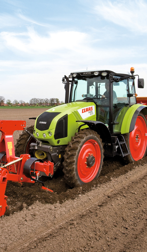 Большой комбайн сеет в поле 