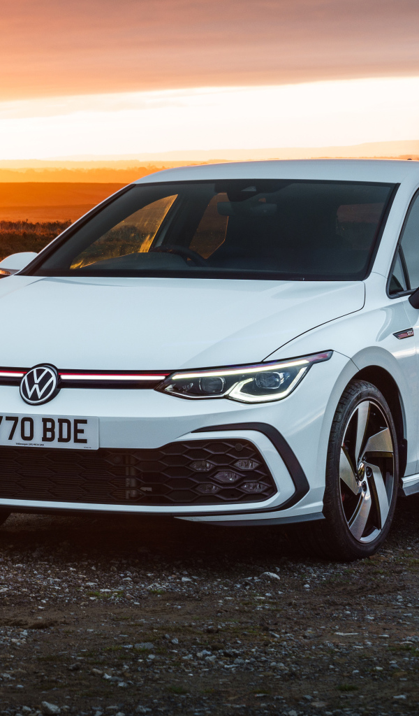 Белый автомобиль Volkswagen Golf GTI 2020 года на закате солнца
