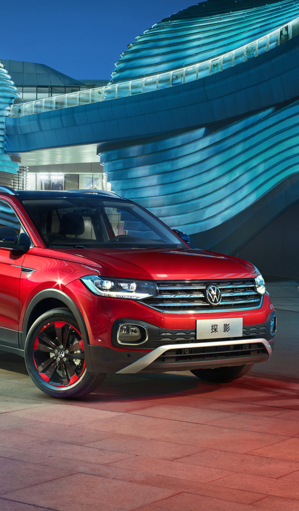A pair stands at the red Volkswagen Tacqua 280 TSI 2019 SUV