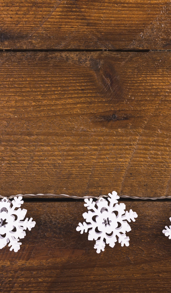 Белые снежинки на деревянном фоне