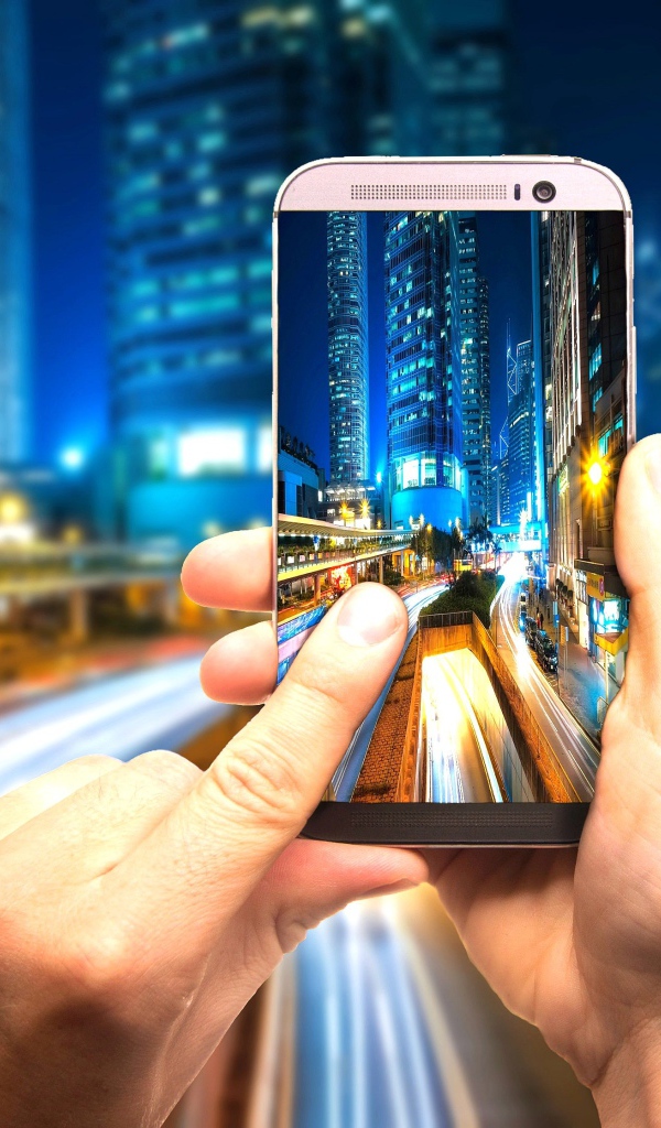 Мужчина делает фото ночного города на смартфон 