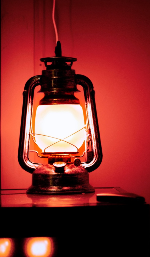 Керосиновая лампа стоит на столе в винном погребе 