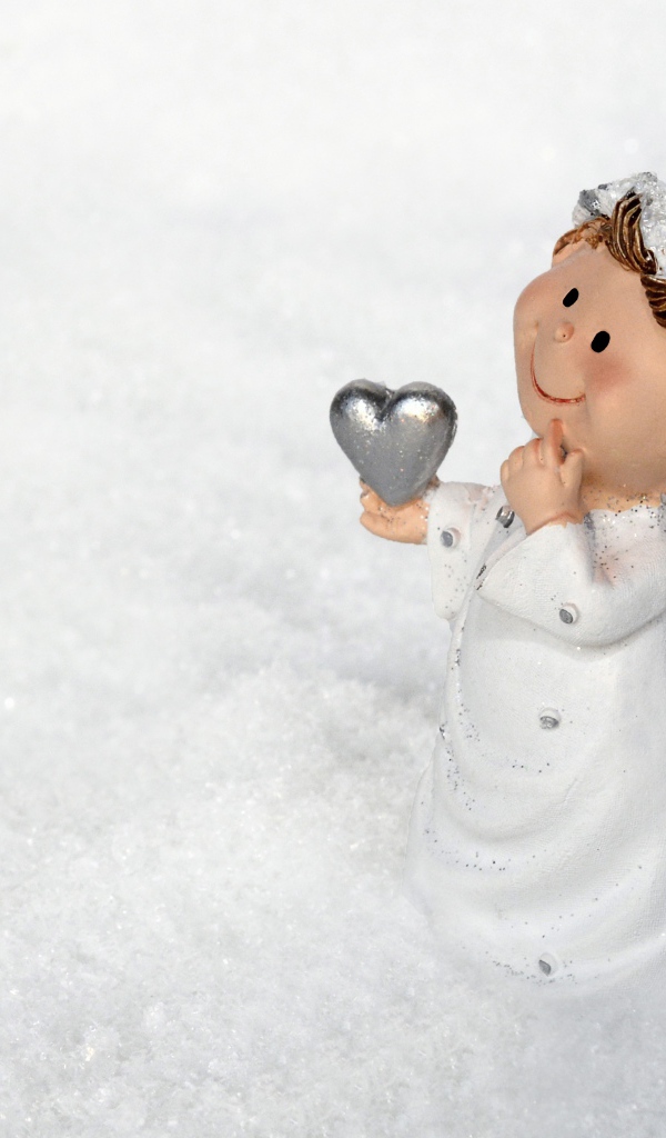 Статуэтка ангела стоит на снегу 