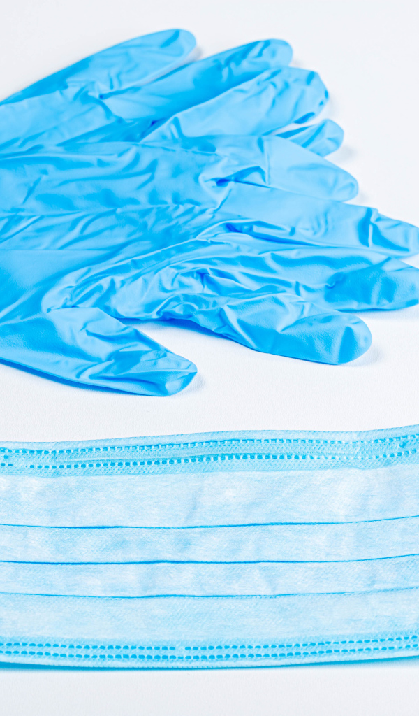 Синие перчатки и маска для лица на белом фоне от коронавируса 