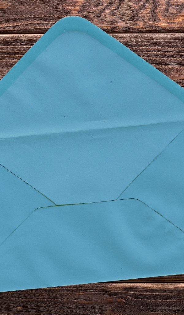 Голубой бумажный конверт на деревянном фоне