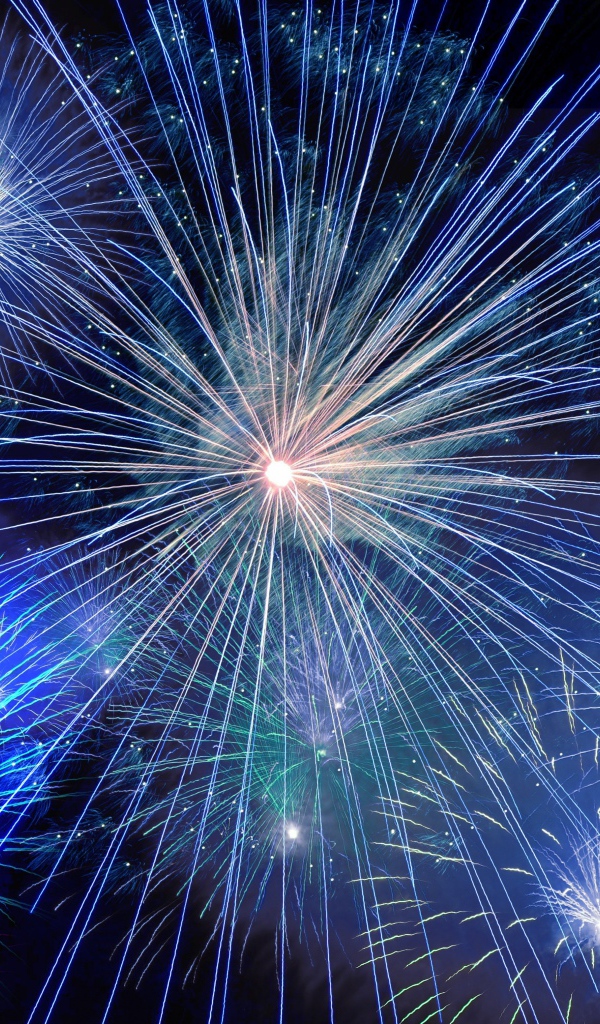 Яркие искры голубого фейерверка в темном небе