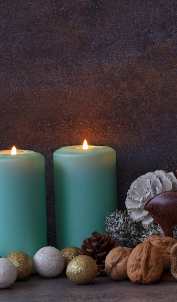 Зажженные свечи на фоне стены с декором