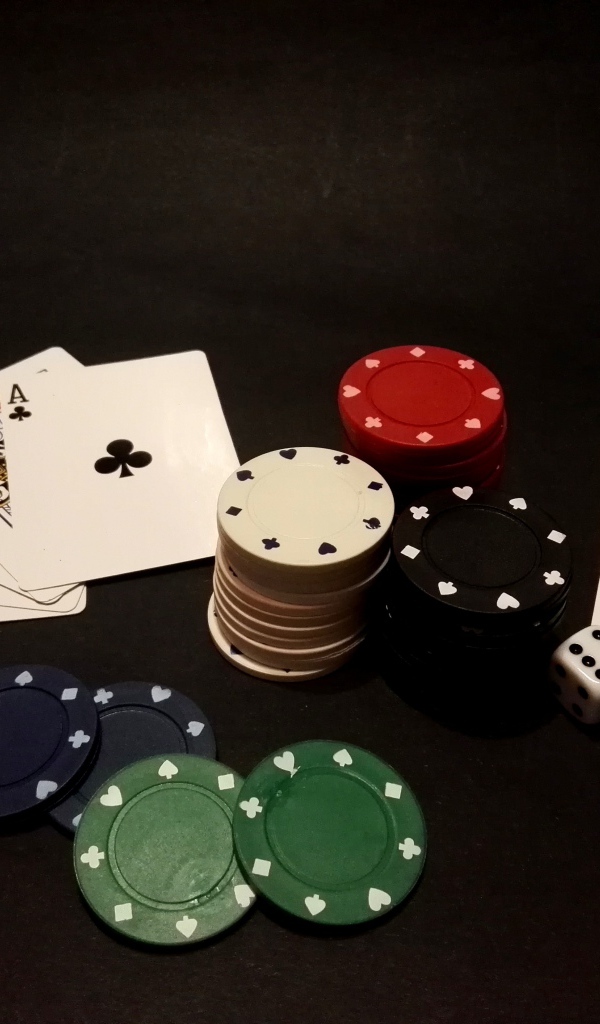 Фишки и карты для игры в покер на черном столе 