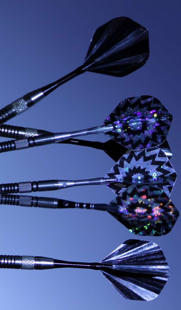 Дротики в доске для дартс на синем фоне 