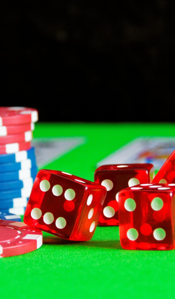 Игральные кости, карты и фишки на столе