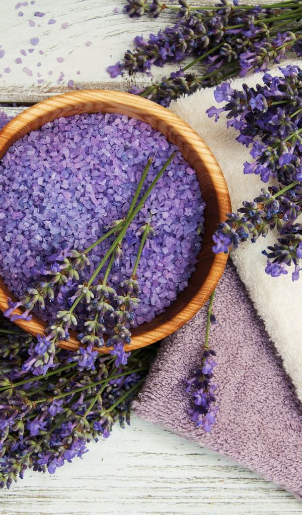 Fragrant salt, on a table with towels, lavender and candles