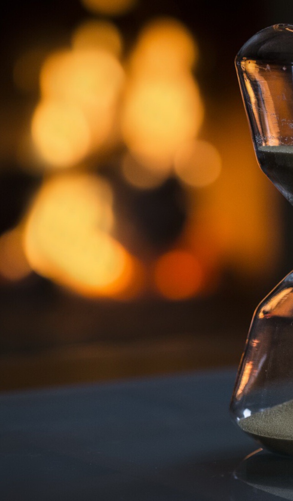 Стеклянные песочные часы на столе 