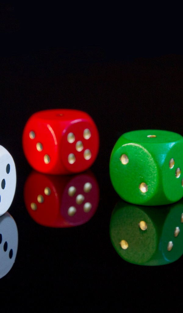 Разноцветные игральные кубики на черном фоне