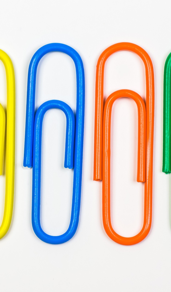 Multicolored paper clips on white background
