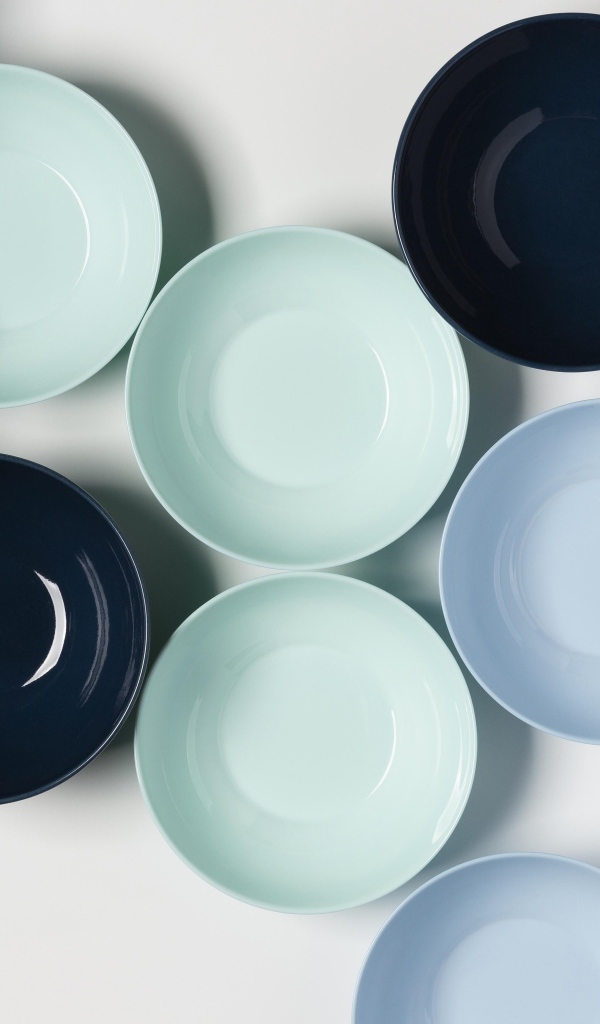 Разноцветные фарфоровые миски на столе 