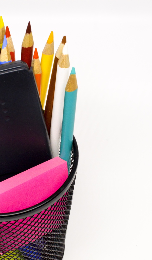 Канцелярские предметы в черном стакане на белом фоне 