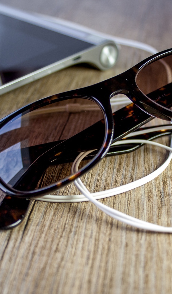 Солнечные очки с наушниками на столе