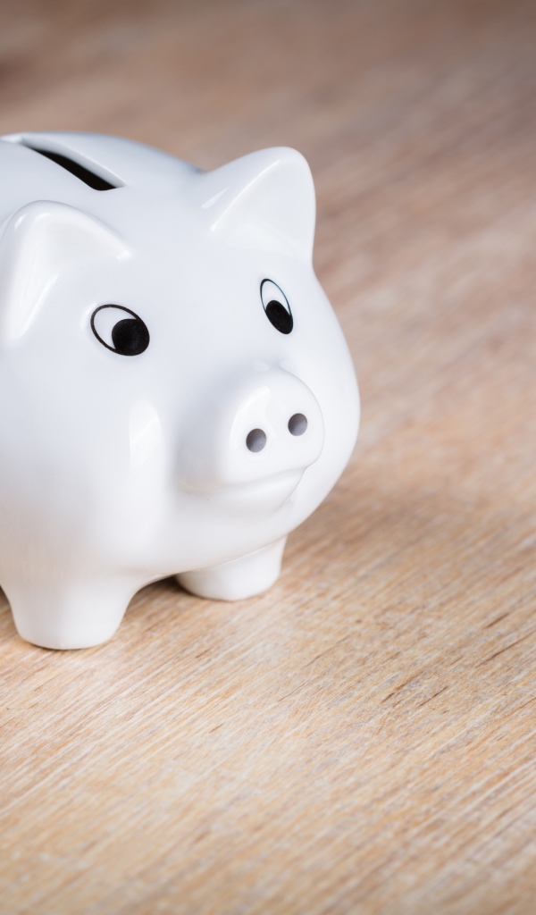 Белая свинья копилка на столе 