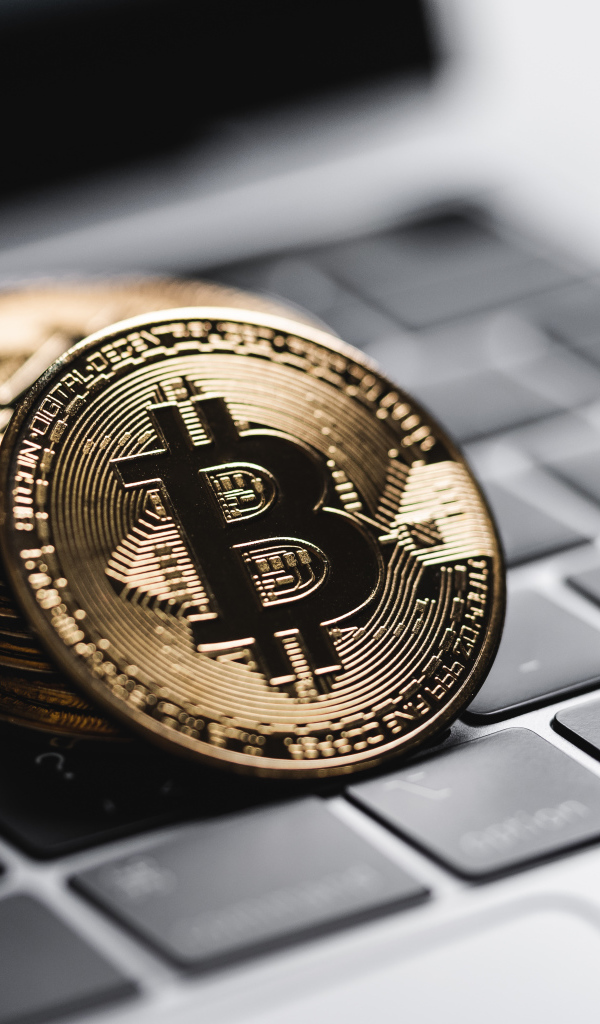 Монеты биткоин лежат на клавиатуре ноутбука 