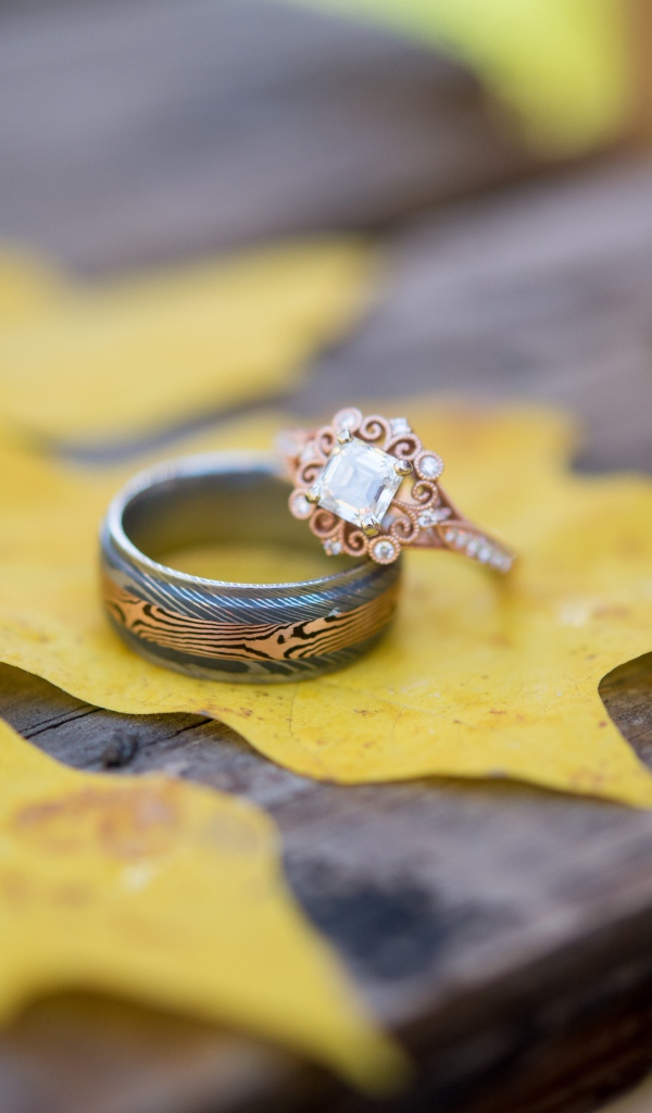 Золотые кольца с желтым листом на столе 