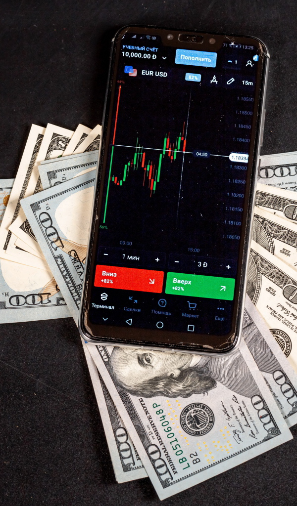 Доллары и смартфон на сером столе 