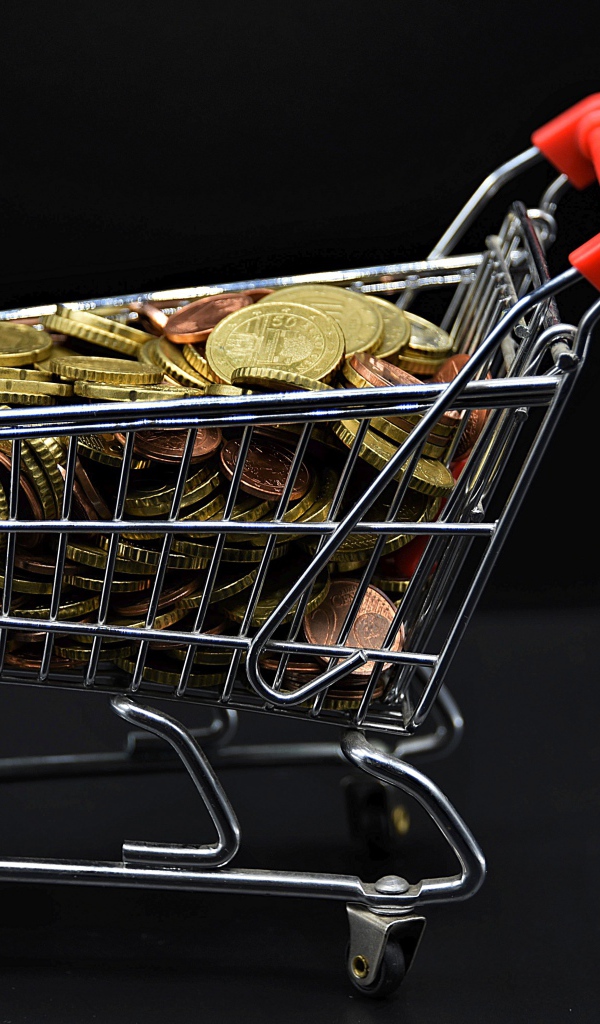Железная тележка с монетами на черном фоне 