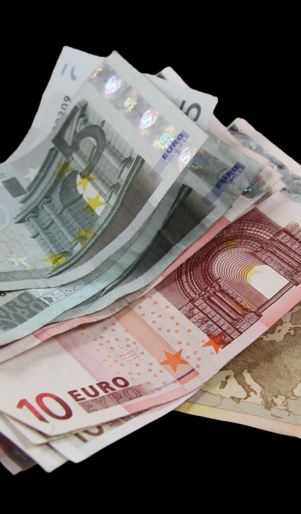 Много бумажных купюр евро на черном фоне