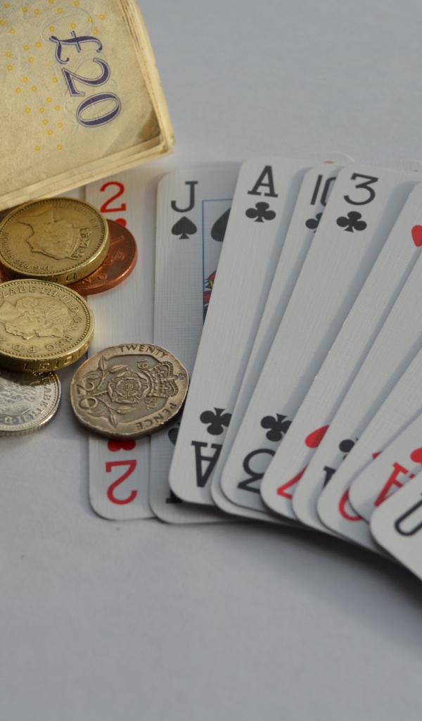 Деньги, монеты и колода карт на столе